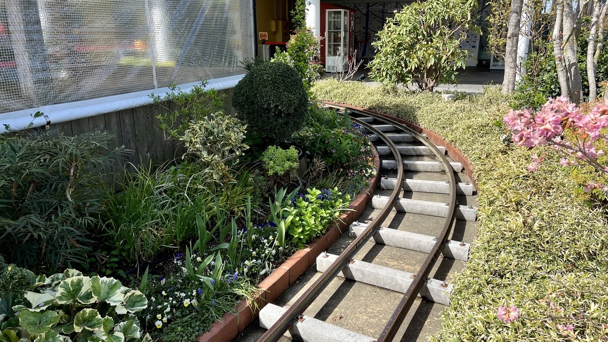 The narrow rails and sleepers of the Tsubame Train curving through the plants