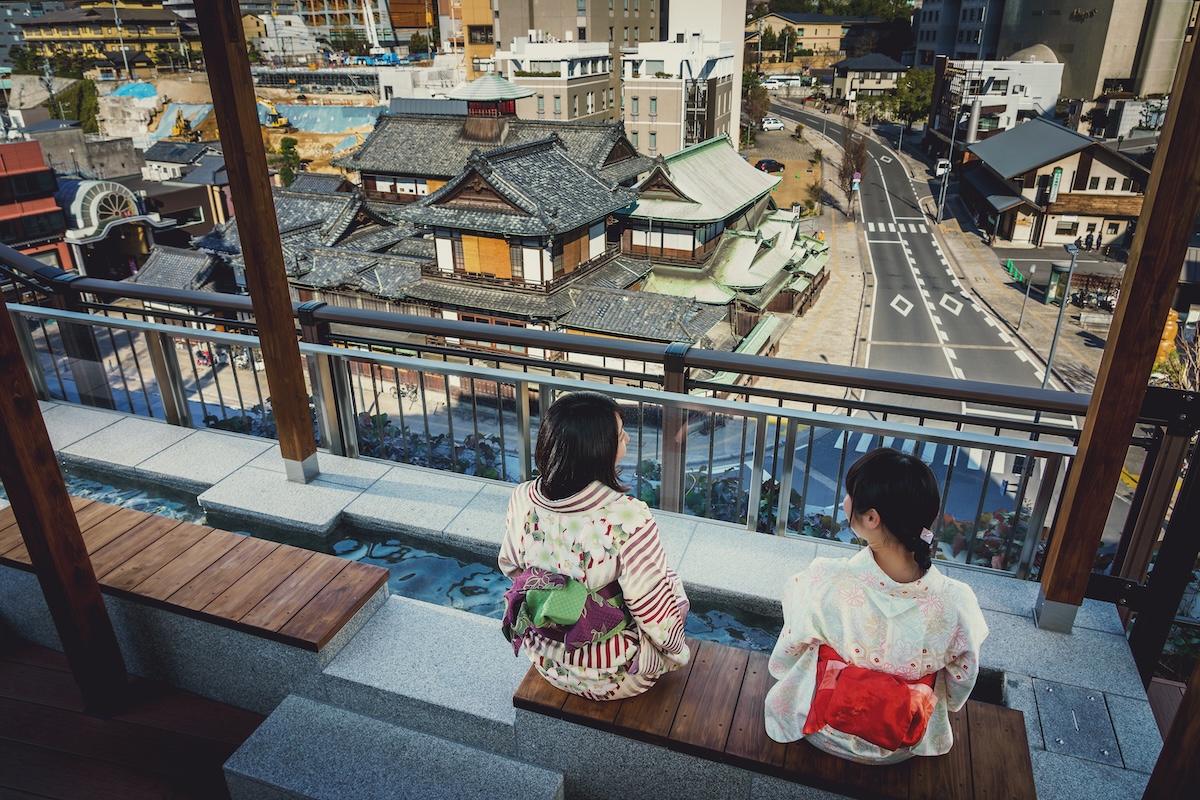 白天泡足湯的兩位穿浴衣女性和本館
