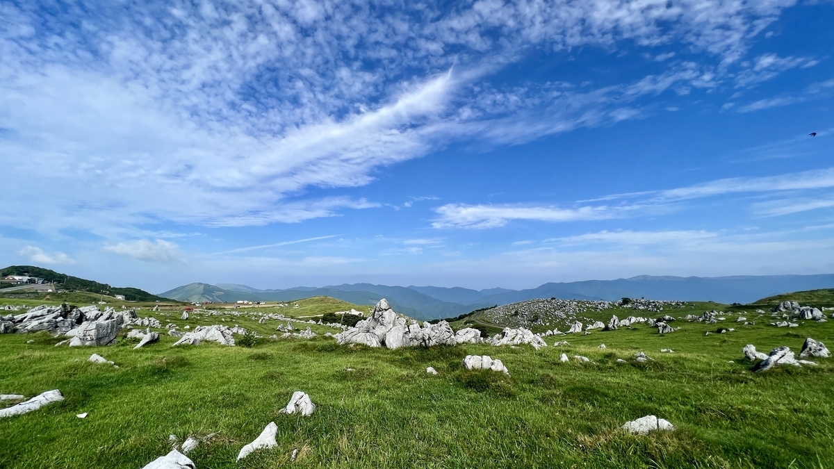 岩石與草原一望無際展開的四國喀斯特絕景與藍天對比