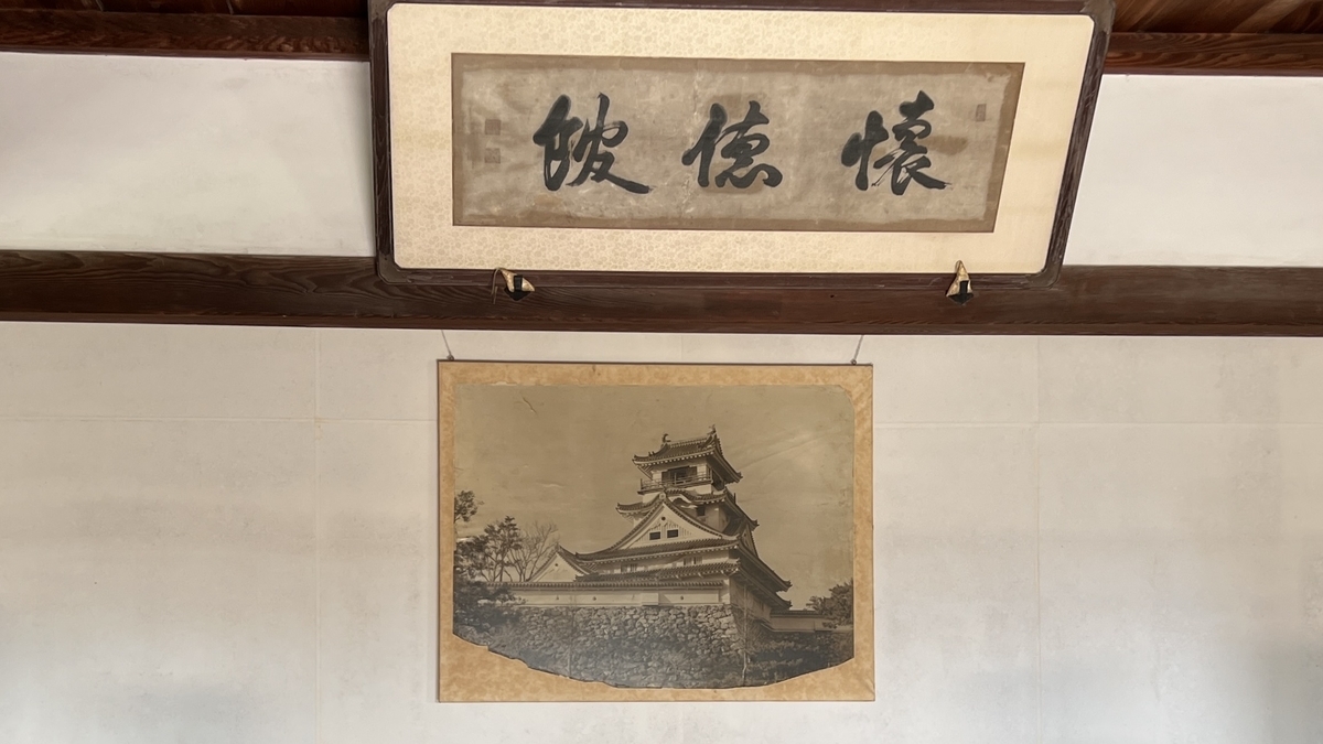 Historical image of the keep and 'Kaitokukan' calligraphy displayed at the entrance.