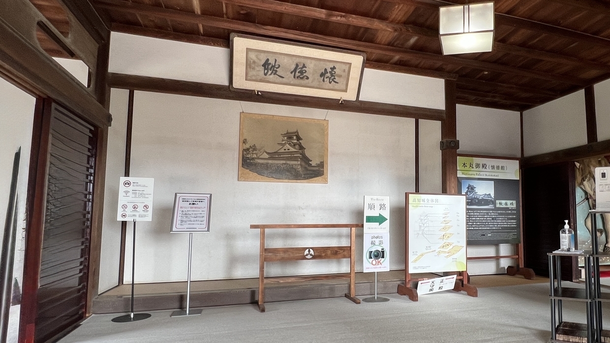 Entrance hall of Kaitokukan, featuring an old photo of the castle and a calligraphy piece.