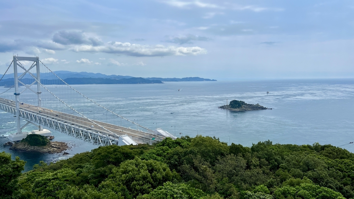 วิวสะพานโอนารุโตะและช่องแคบนารุโตะที่เห็นได้จากหลังต้นไม้