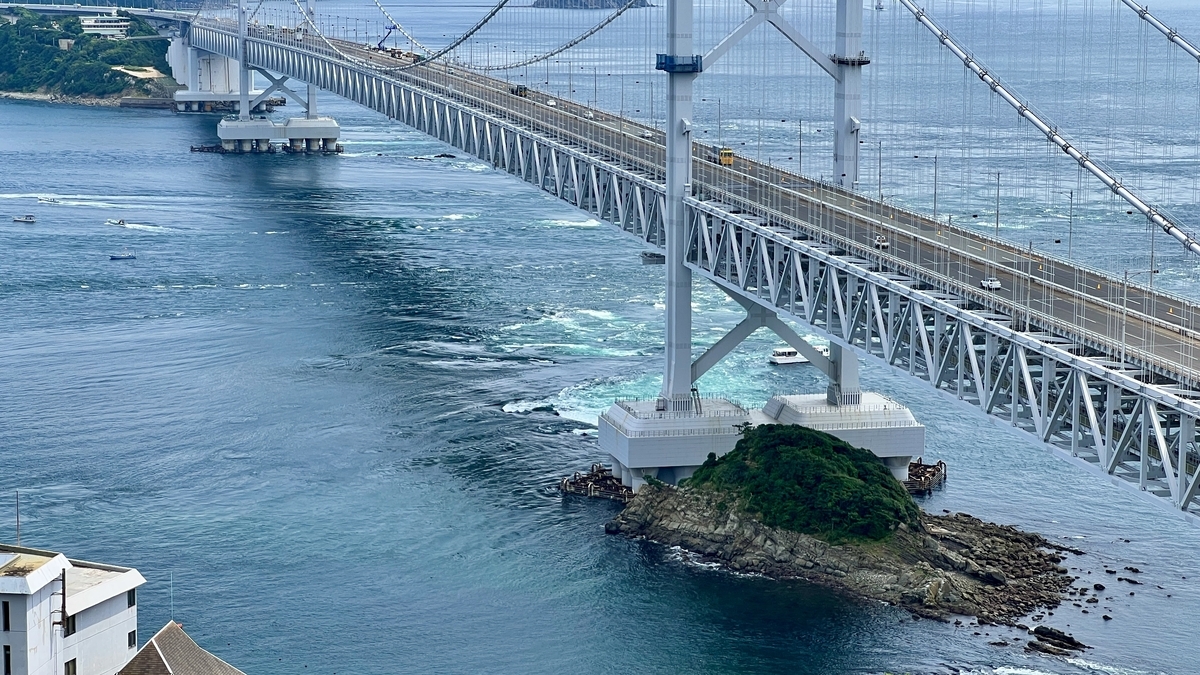 ภาพใกล้ของสะพานโอนารุโตะและคลื่นทะเลที่มีพลัง