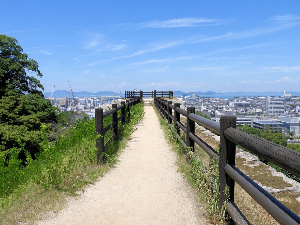 A walking path atop the stone walls in the sannomaru area of Marugame Castle, developed into a scenic viewpoint. The sea and city can be seen in the distance.