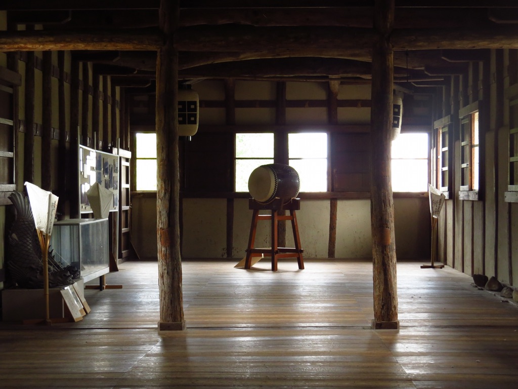 Interior of Ote Ichino Gate at Marugame Castle, featuring a drum and wooden architecture. Stage for the drum experience.