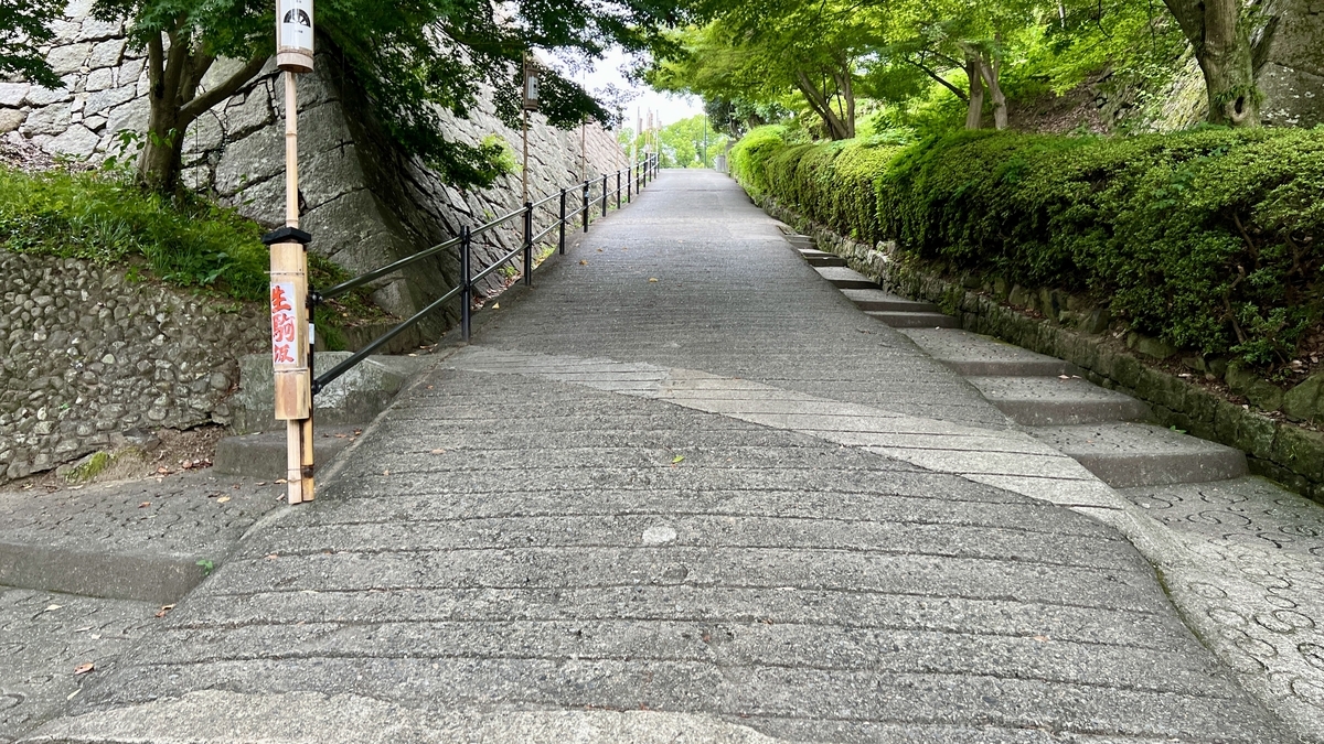 The upper half of Mikaeri-zaka, featuring a steep stone path. Entrance to the sannomaru visible ahead.