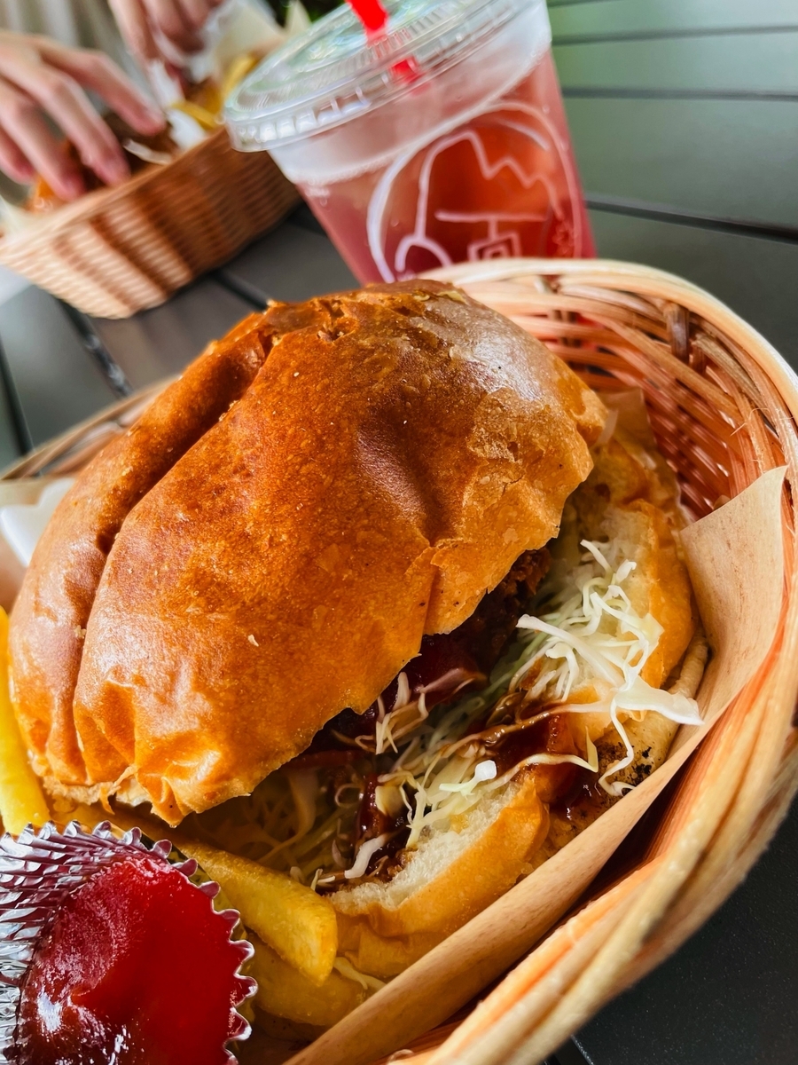 Hamburguesa de croqueta de res con aceitunas acompañada de papas fritas