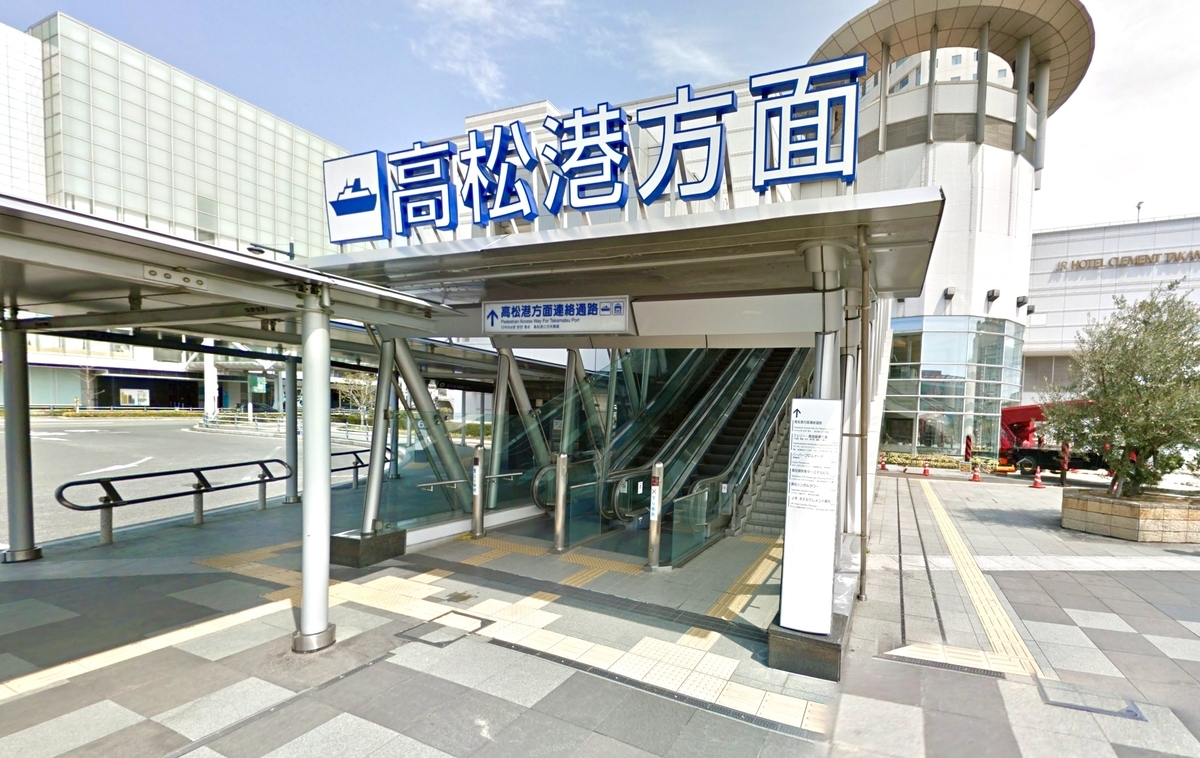 Señal de dirección desde la estación JR Takamatsu hacia el Puerto de Takamatsu y pasillo cubierto para peatones