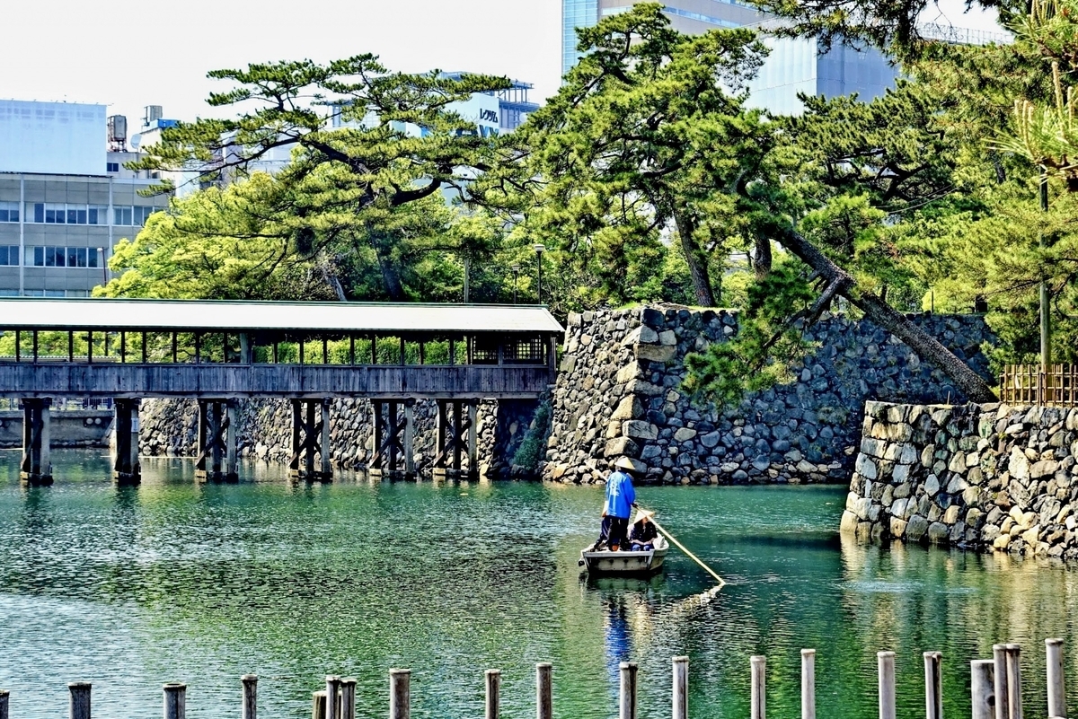 เรือญี่ปุ่นที่เดินทางในคูน้ำภายในและทิวทัศน์ริมน้ำของปราสาททาคามัตสึที่ล้อมรอบด้วยกำแพงหิน ทิวทัศน์การท่องเที่ยวพร้อมคำแนะนำจากลูกเรือ