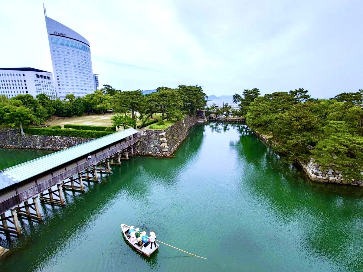 เรือญี่ปุ่นที่เดินทางอย่างช้าๆ ในคูน้ำภายในและเส้นทางเที่ยวชมริมน้ำของปราสาททาคามัตสึที่ล้อมรอบด้วยธรรมชาติ