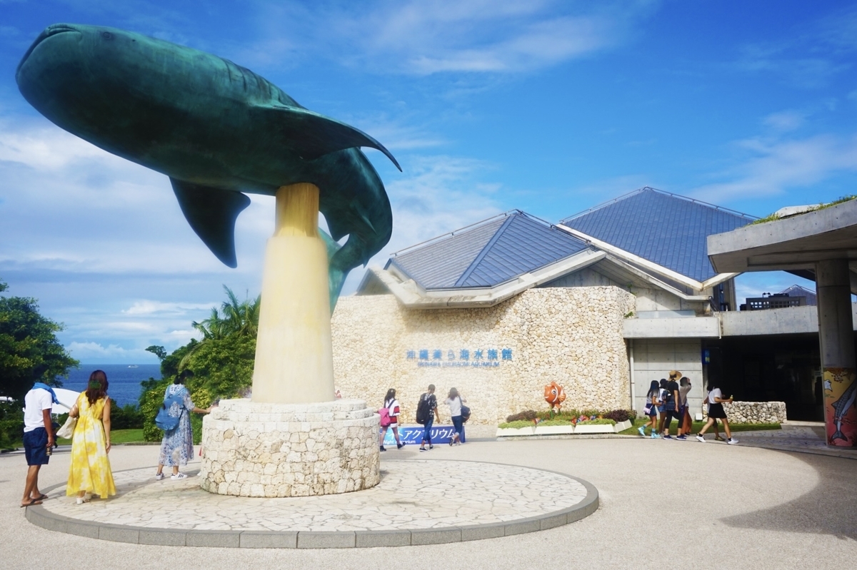美ら海水族館入口にあるジンベエザメの大きなモニュメントと来館者の様子