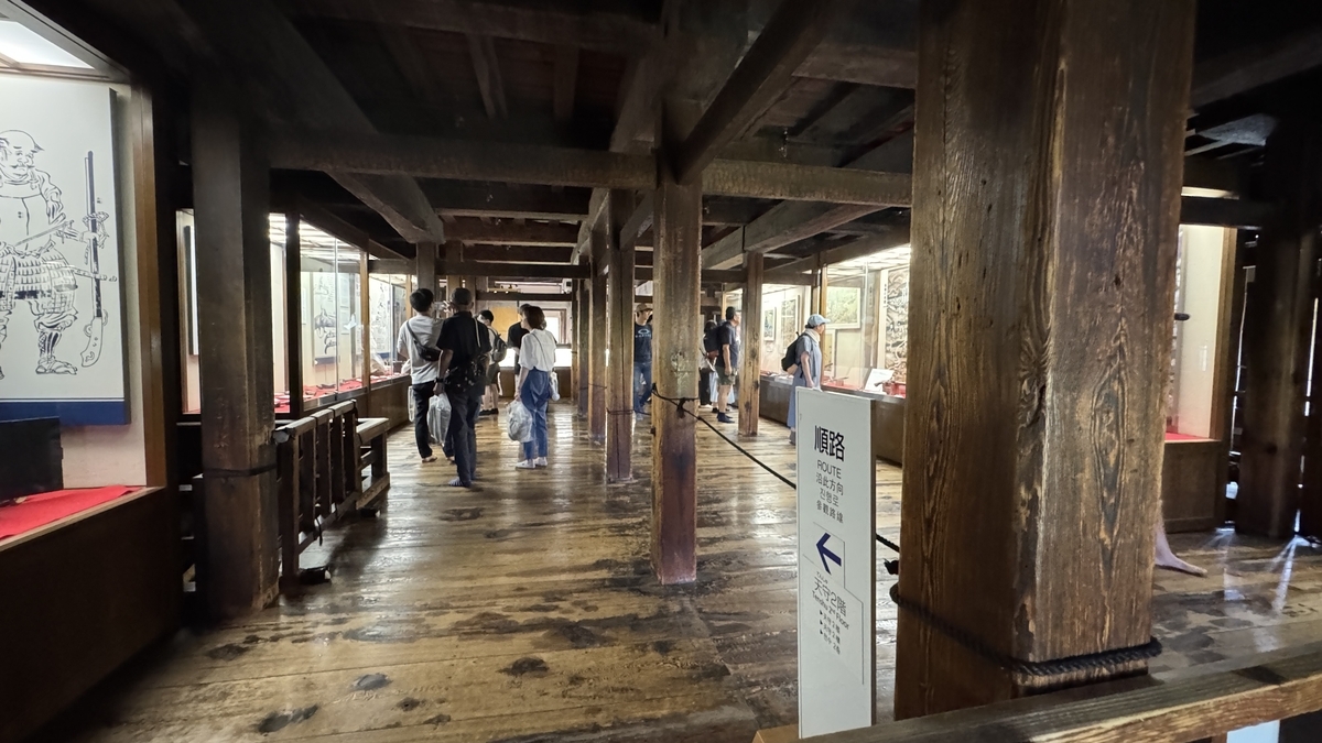 Exhibit hall corridor with rows of matchlock guns and samurai armor