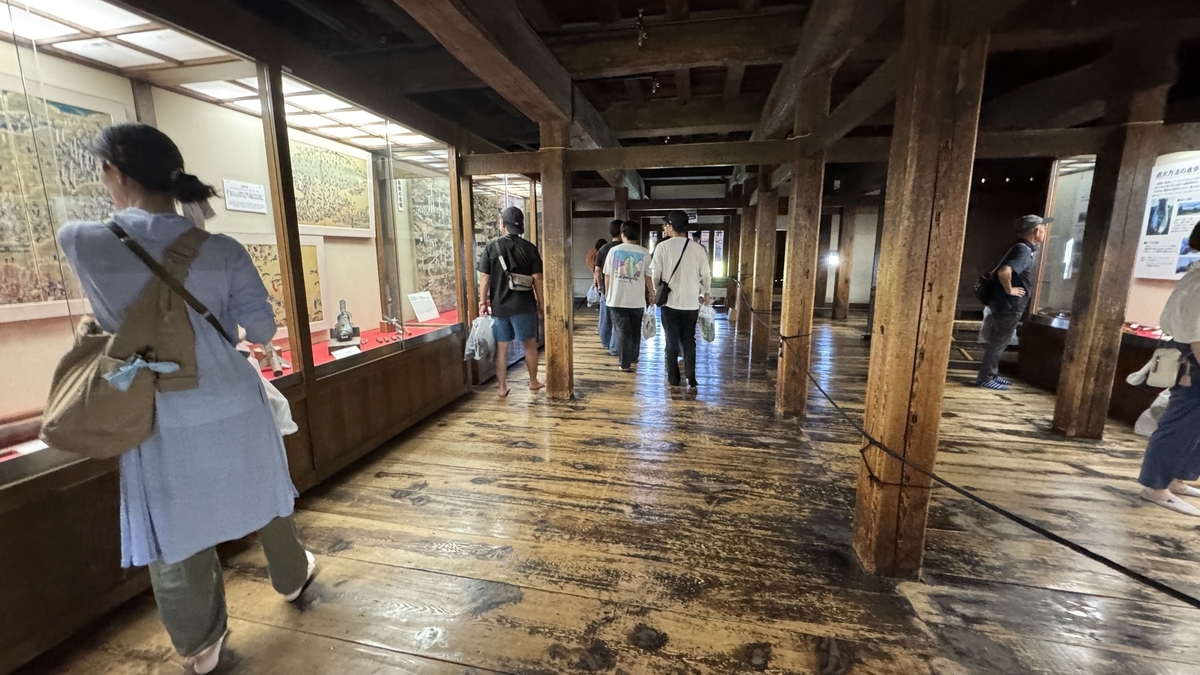 Visitors observing matchlock gun displays on the second floor