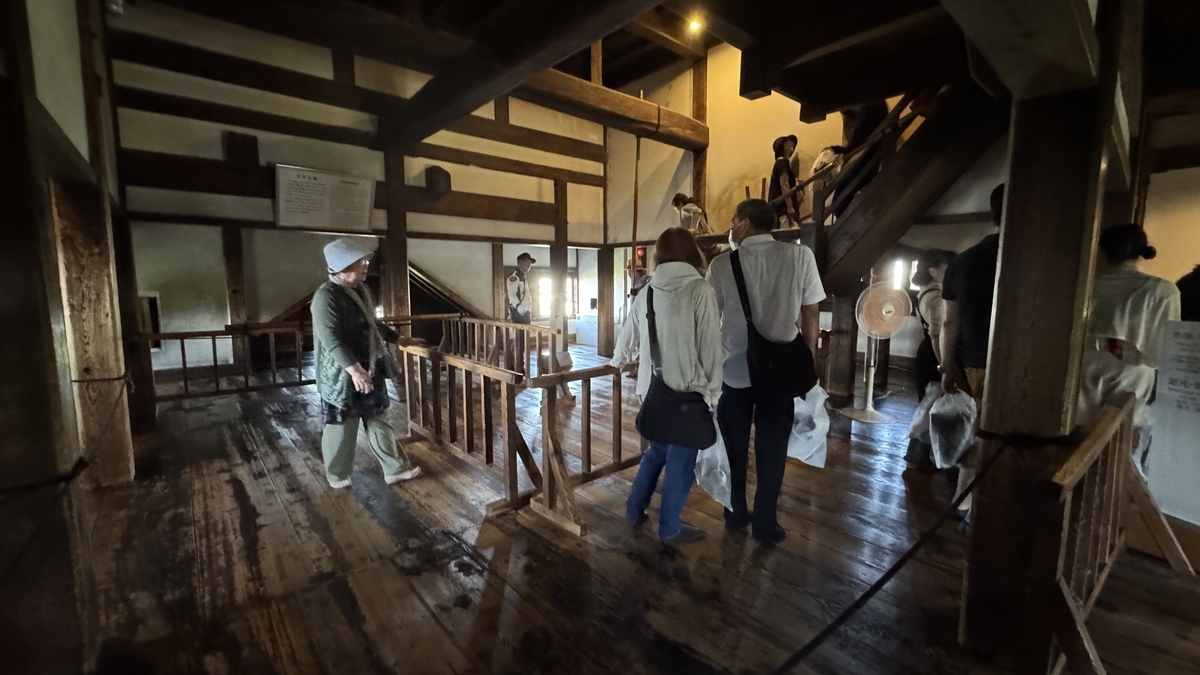Visitors inside the fifth floor wide wooden hall with beams