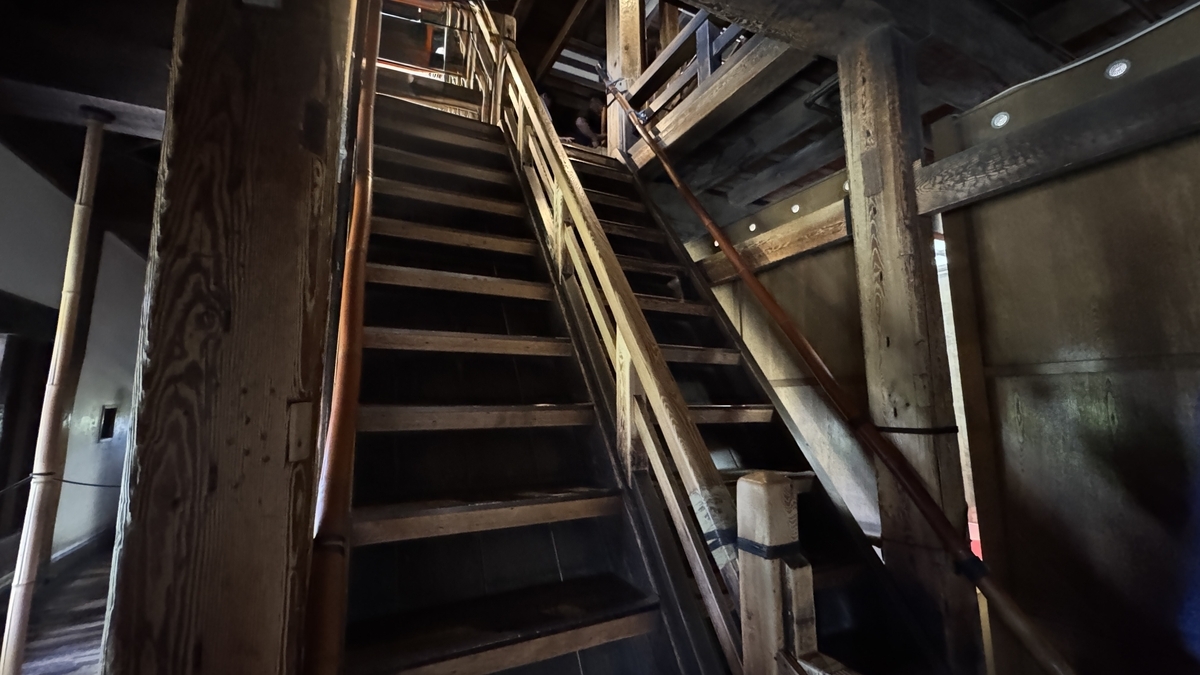 Looking up a steep wooden staircase inside the keep