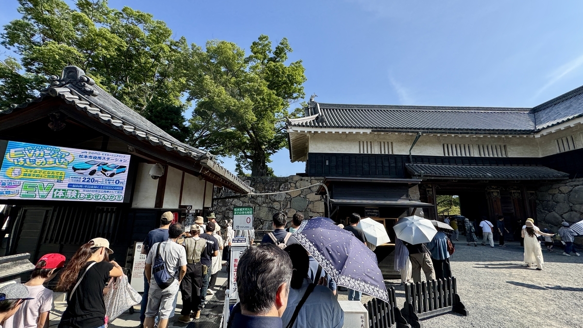 Line of people buying paper tickets at the entrance to Matsumoto Castle