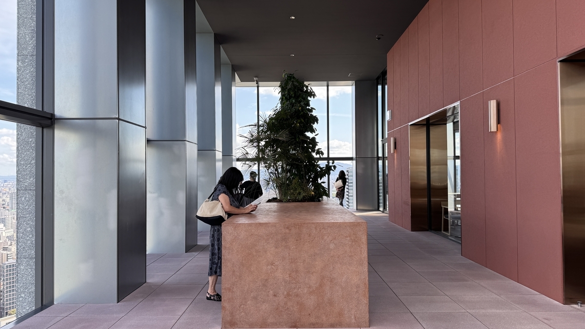 Área interior de Yodoyabashi Sky Terrace con mesas tipo barra y plantas decorativas