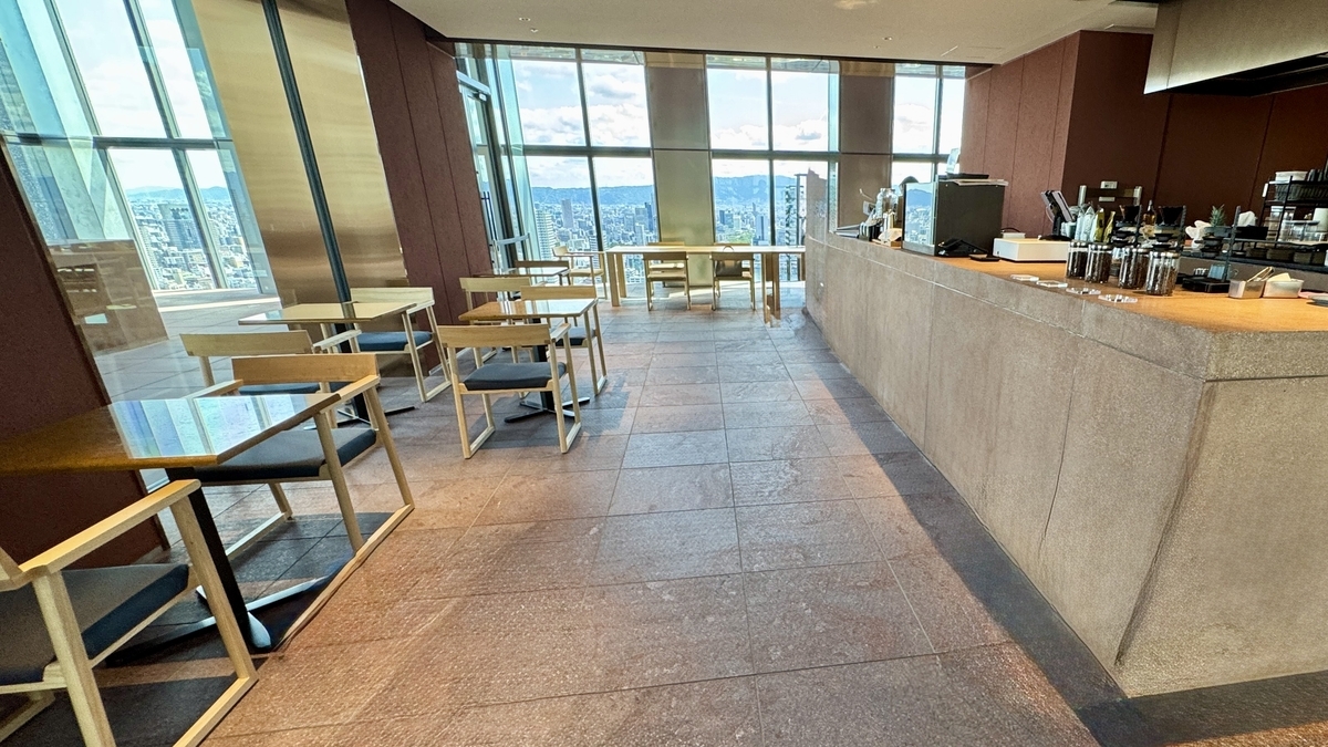 Interior del SkyTerrace Cafe and Bar con luz natural y mesas con barra