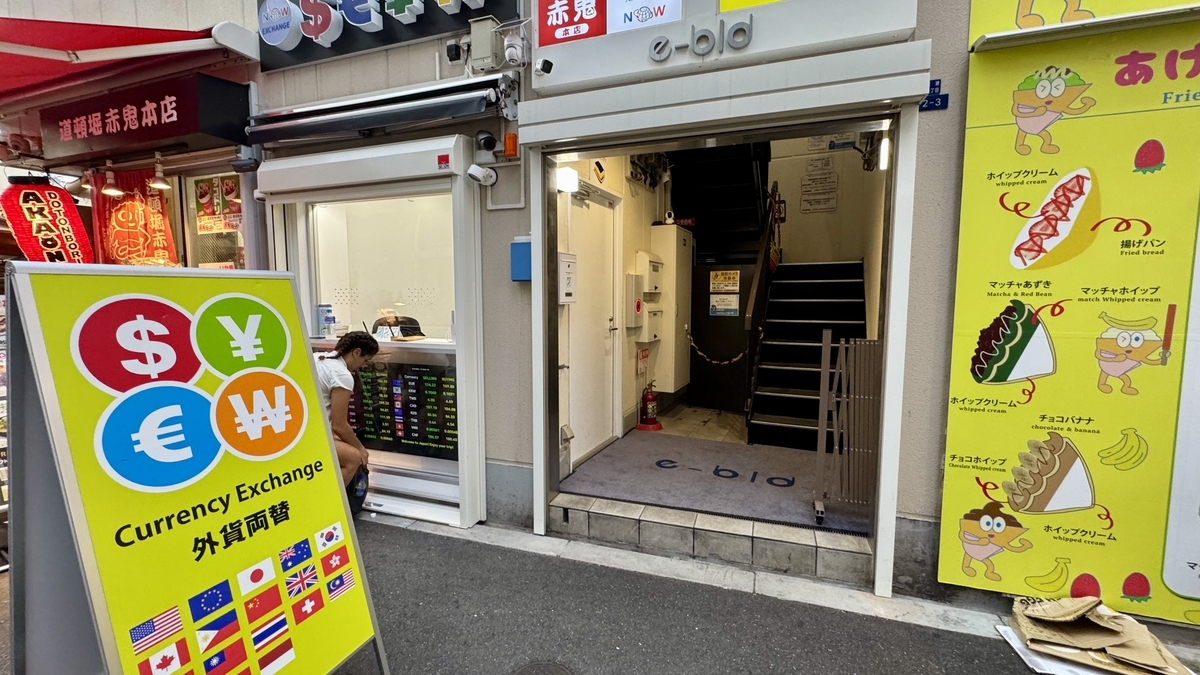 ด้านหน้าของ NOW CURRENCY EXCHANGE สาขาโอซาก้า Sennichimae ในย่านโดทงโบริ ร้านแลกเงินแบบหน้าร้านริมถนน