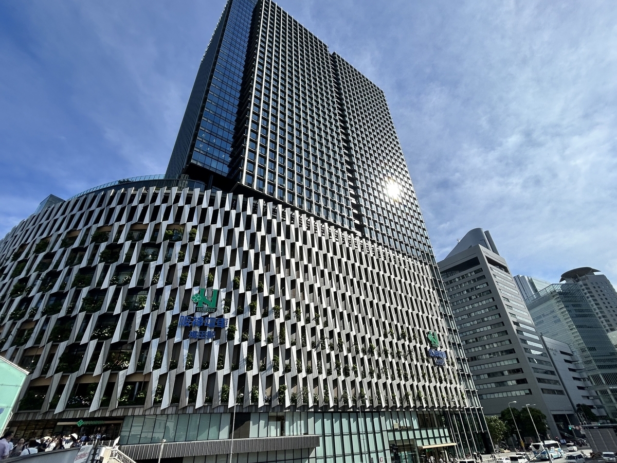 Exterior view of Hanshin Umeda Main Store. The tall building housing Hanshin Dai-Shokudo on the 9th floor stands under a clear blue sky.