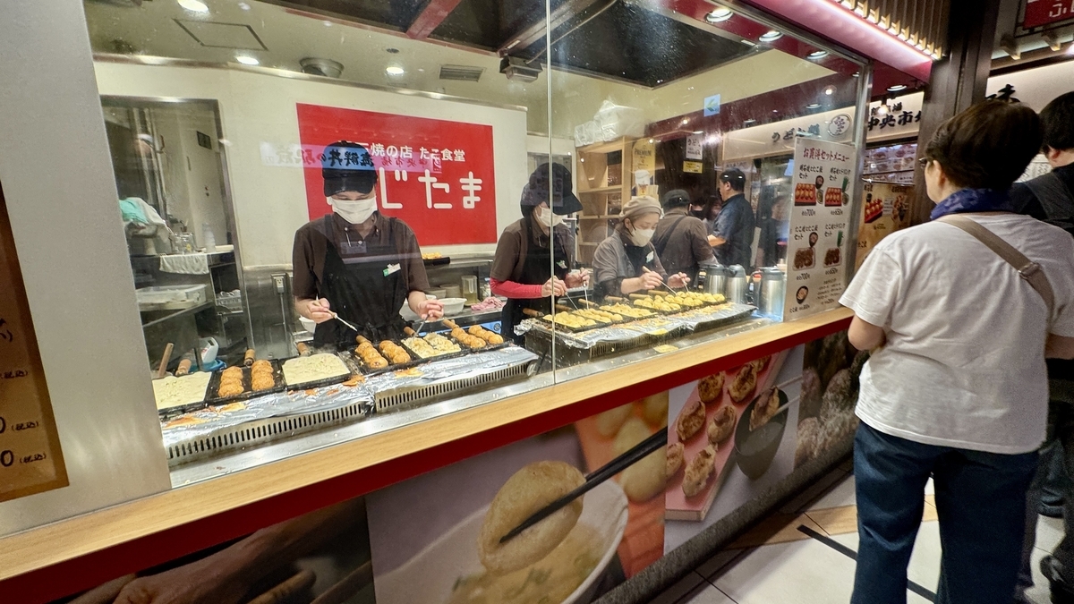 寿司店魚がし日本一のカウンター。職人がその場で寿司を握る様子が見える