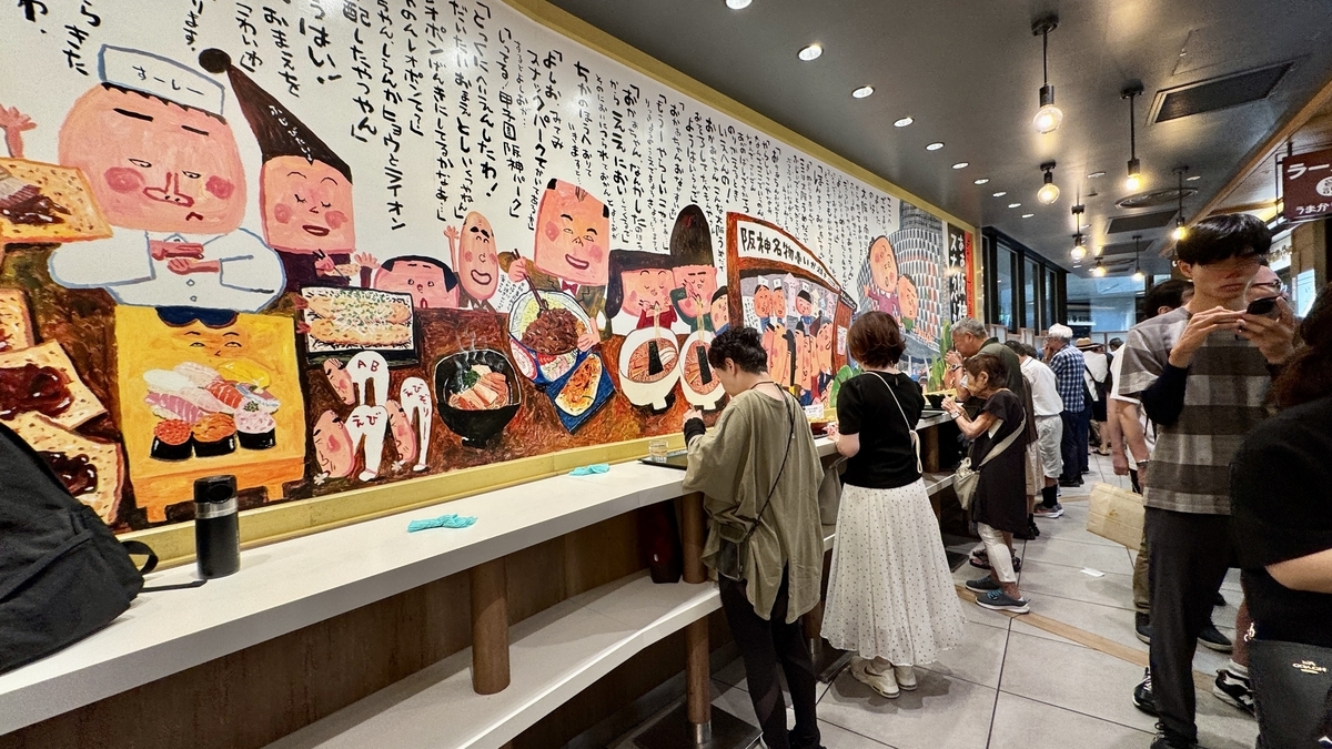 スナックパークの壁面に描かれた大阪名物のイラスト。明るくポップな雰囲気の立ち食いエリア