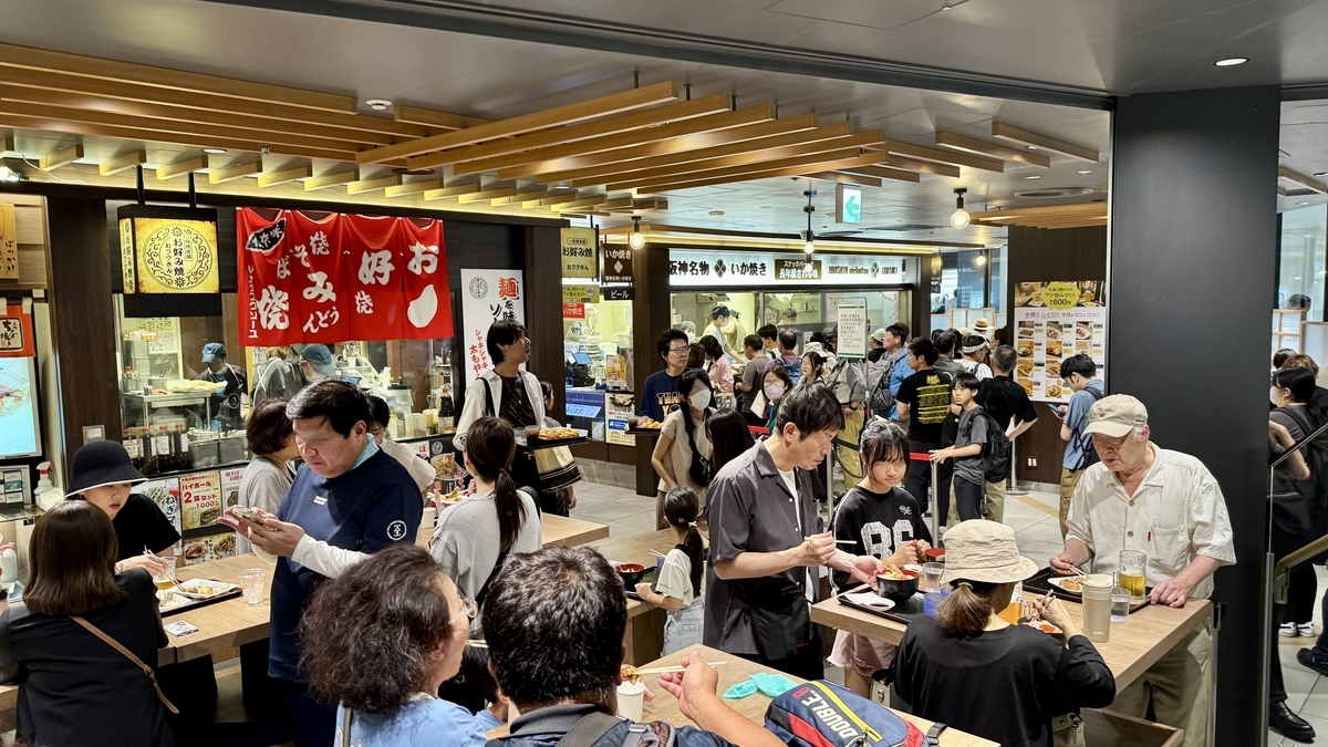 スナックパーク中央の立ち食いカウンター。利用客で賑わう食事風景