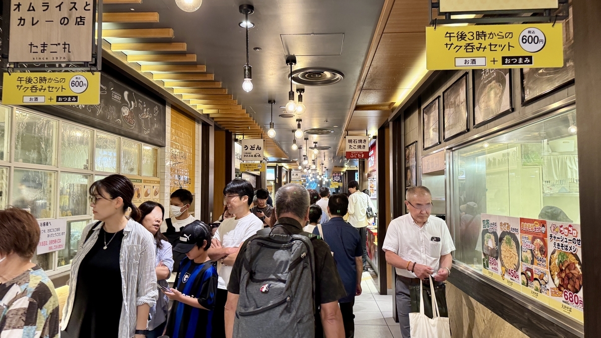 スナックパークの通路。多くの来店客が立ち食いや買い物を楽しむ様子