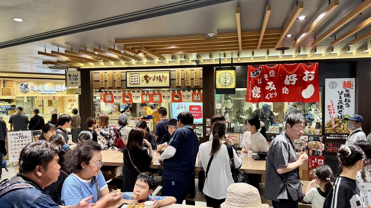 阪神スナックパーク内の店舗前通路 立ち食いを楽しむ人々でにぎわう光景