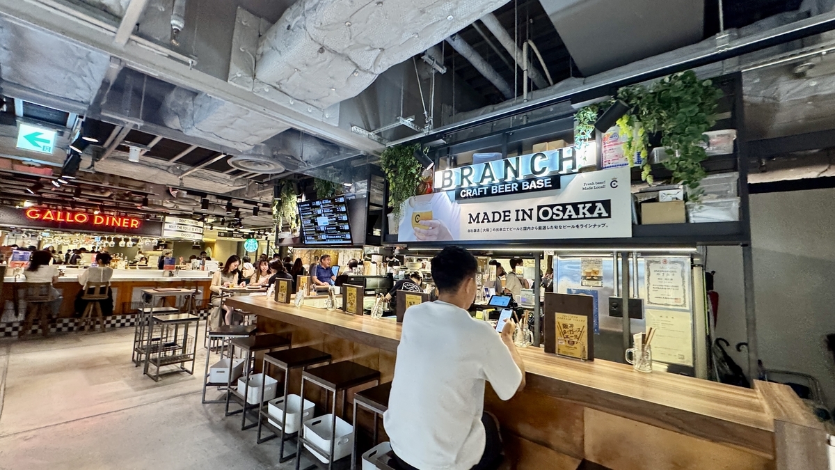 阪神バル横丁バルゾーンのカウンター席 おしゃれな空間で一人飲みを楽しむ人の姿