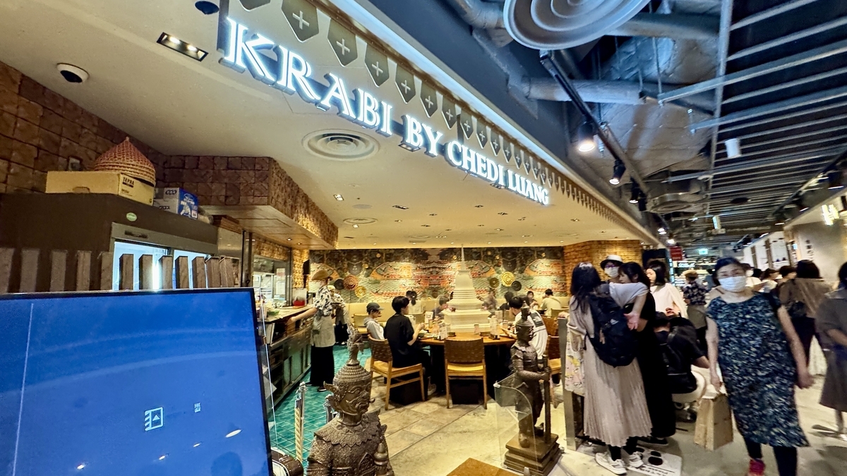 阪神バル横丁内のアジアンレストラン 店先で料理を選ぶ人々の様子