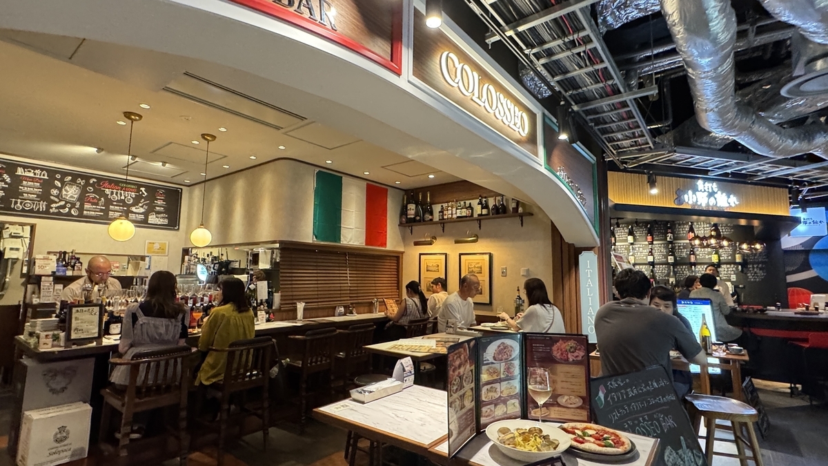 コロッセオバルの店内で食事を楽しむ人々と温かな照明のカウンター席