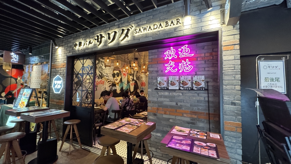 中華バルサワダの店頭とネオンサインが光る入口