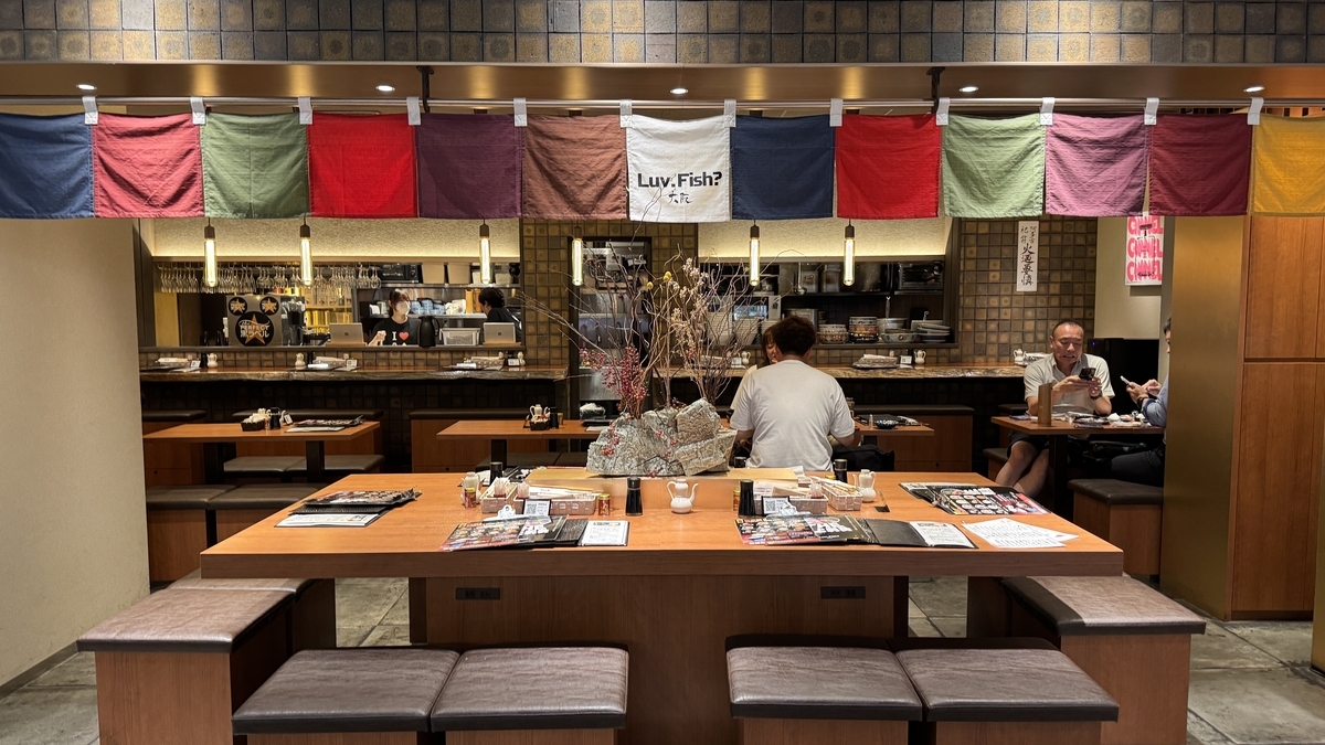 LuvFish大阪の店内とカウンター席に並ぶ客の様子