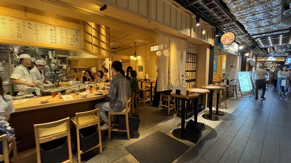 ヤマニの店内とカウンター席に並ぶ客の様子