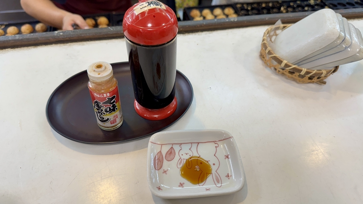 Set of condiments including nibaizu and shichimi placed on the counter at Ichifuku