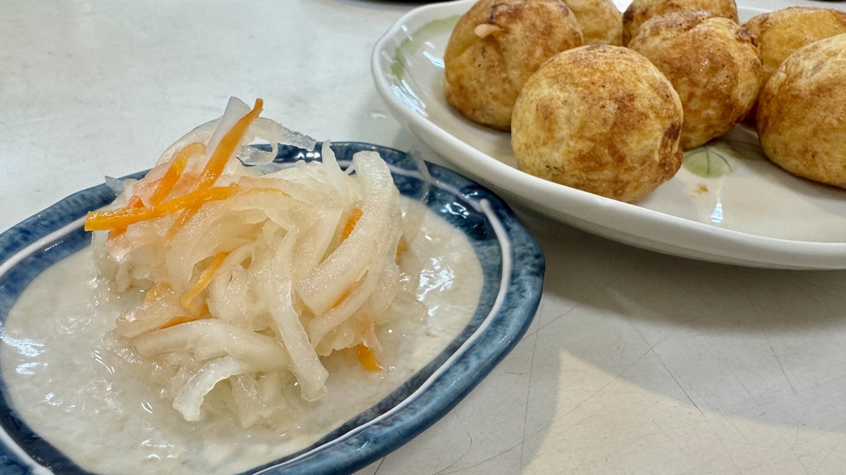 Small bowl of namasu served with takoyaki, featuring balanced sweet and sour flavor