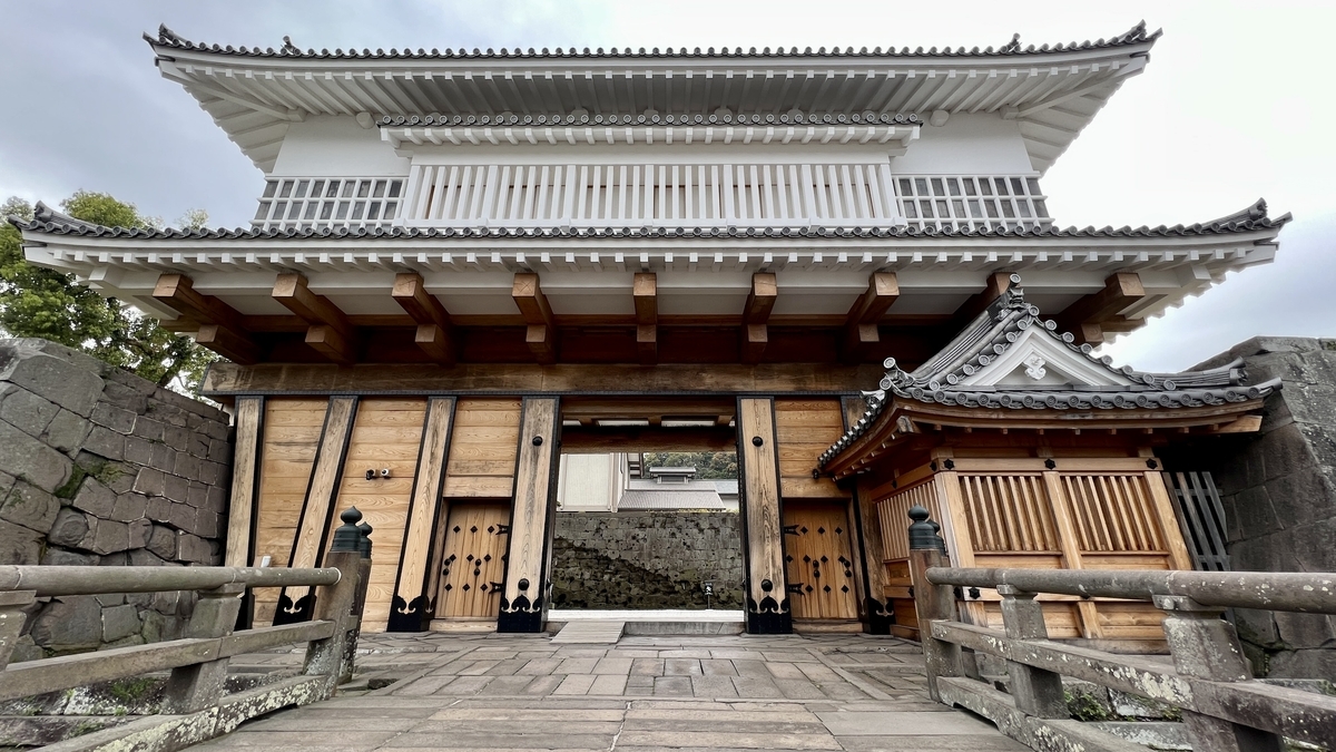 Lush greenery and flowers surrounding the front of Goromon Gate at Kagoshima Castle Ruins