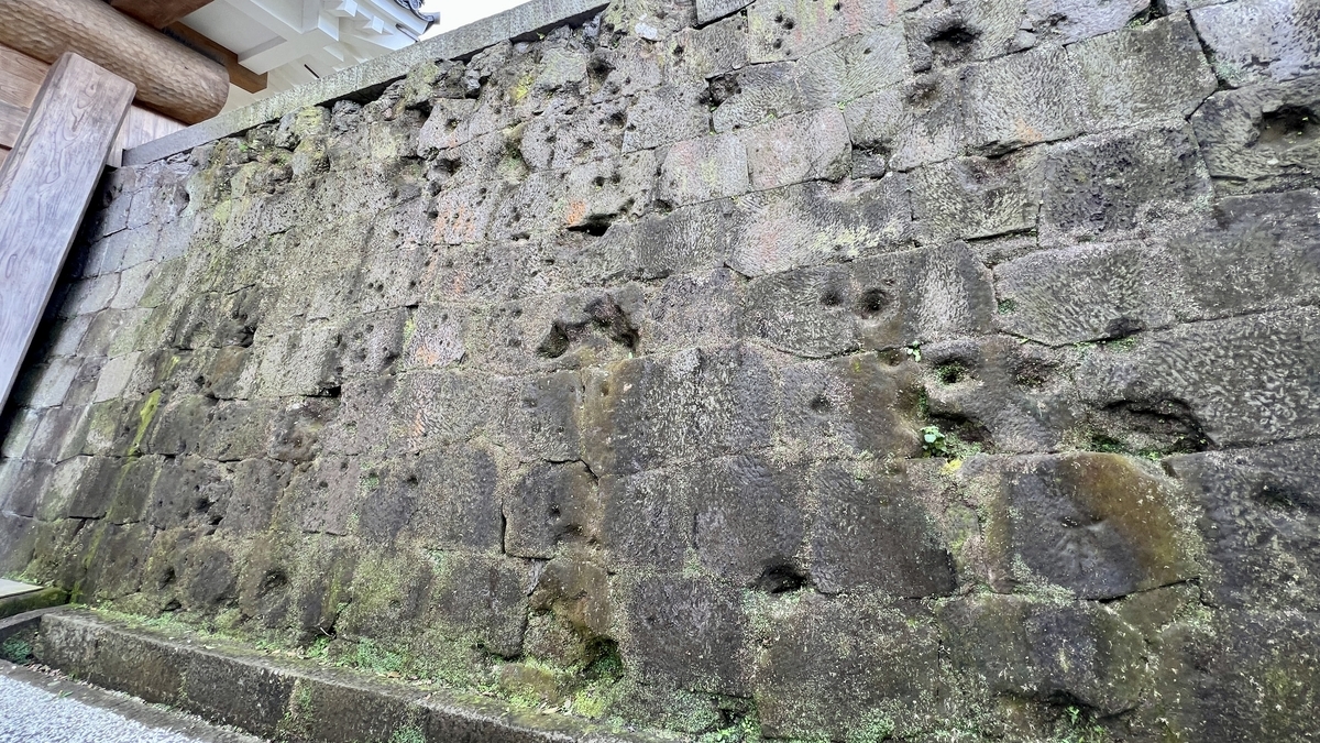Close-up of stone walls at Kagoshima Castle Ruins marked with countless bullet holes