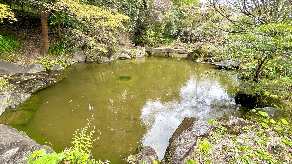 Calm garden view with the Kyuko Bridge crossing the reflective Oike pond