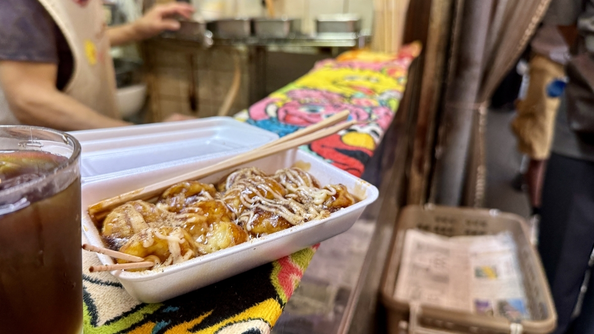 Enjoying freshly made takoyaki at the stand counter