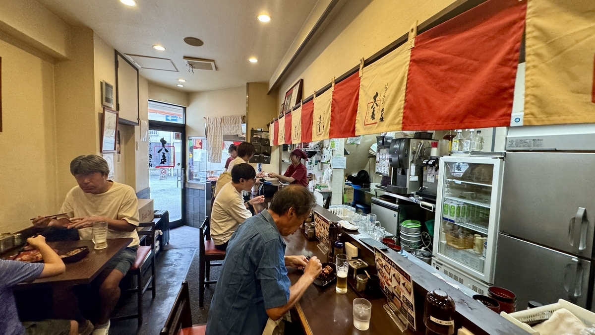 노렌과 조명이 따뜻한 느낌을 주는 타코야키 주하치반 니시나카지마 본점의 매장 풍경