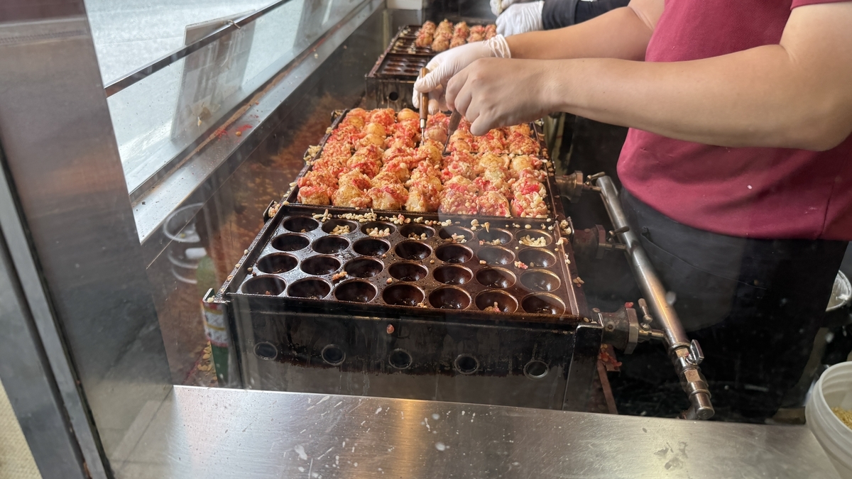 굽는 판에서 장인이 타코야키를 굽고 있는 모습