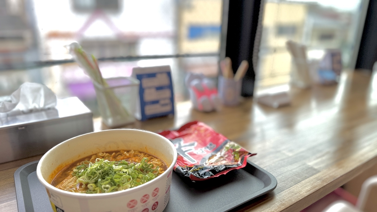 窓際カウンターに置いたラーメンと街並み 鶴橋で味わう漢江気分