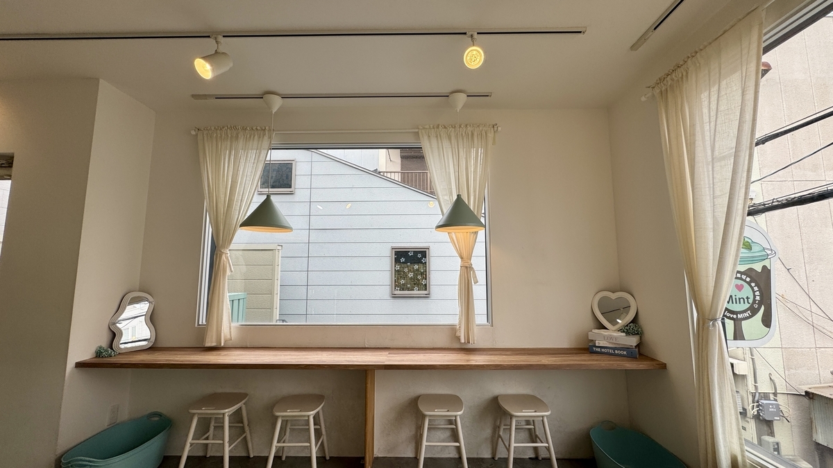 โซนที่นั่งริมหน้าต่างที่แสงธรรมชาติและโทนสีมิ้นต์ผสมผสานกันอย่างลงตัว