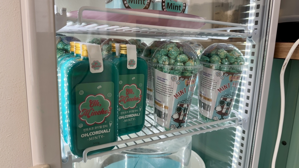 เครื่องดื่มสีมิ้นต์และแก้วเรียงอยู่ในตู้แช่