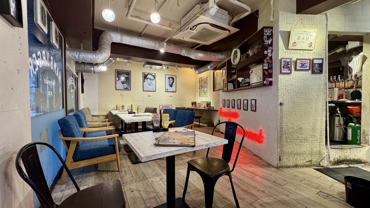 ภายในร้าน RICH GARDEN สาขาชินไซบาชิ มีแสงนีออนสีแดงและโต๊ะไม้