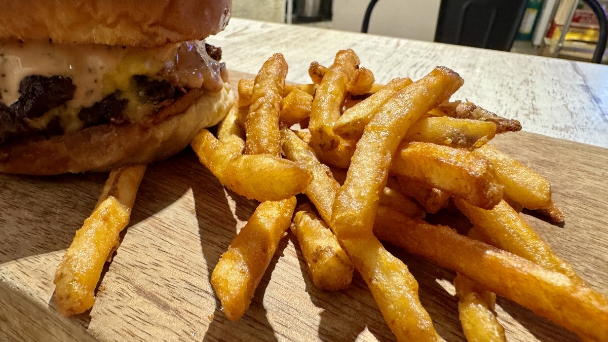 จานที่มี Authentic Double Cheese Burger พร้อมเฟรนช์ฟรายส์กองใหญ่