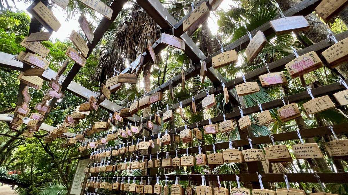 祈りの古道の絵馬が風に揺れ光を受けて輝く様子