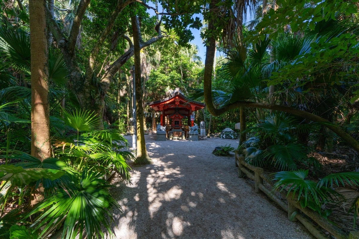 亜熱帯の木々に囲まれた参道の奥に朱色の社殿が佇む青島神社の元宮の風景